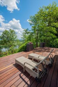 a wooden deck with two benches on top of it at Villa avec vue et piscine à moins d'1h de Paris in Rolleboise