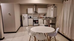 a kitchen with a white table and white appliances at Departamento en Complejo Las Lilas Mendoza in Mendoza