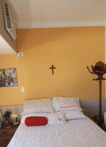 - une chambre dotée d'un lit avec une croix sur le mur dans l'établissement Studio Everest Flat vista mar, à Récife