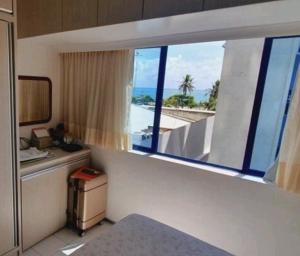 a hotel room with a view of the beach from a window at Studio Everest Flat vista mar in Recife