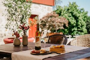 einen Tisch mit einer Flasche Wein und einem Teller Essen in der Unterkunft Casa Lata - Agroturismo e Enoturismo in Amares