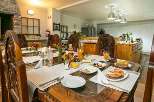 een tafel met daarop borden met eten bij Ravenscliff Manor in Oudtshoorn
