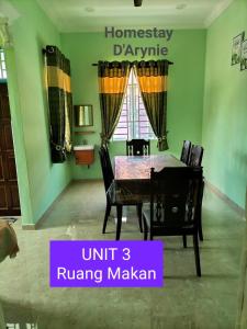 a dining room with a table and chairs at Homestay D ARYNIE in Bukit Payong