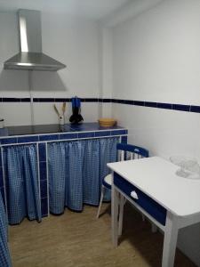 una cocina con encimeras azules y blancas y una mesa en La casa de la tita María Jesús, en Olvera