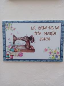 una señal para una máquina de coser con una foto en La casa de la tita María Jesús, en Olvera
