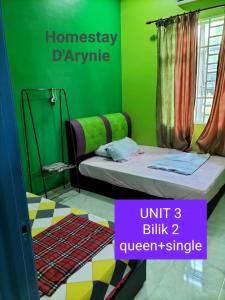 a bedroom with a bed and a green wall at Homestay D ARYNIE in Bukit Payong