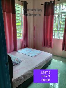 uma pequena cama num quarto com cortinas cor-de-rosa em Homestay D ARYNIE em Bukit Payong