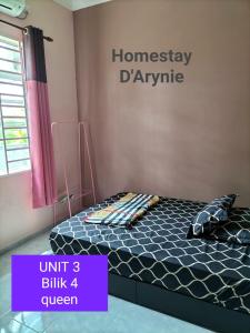 uma cama num quarto com uma placa na parede em Homestay D ARYNIE em Bukit Payong