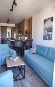 a living room with blue couches and a table at Allure Apartments in Ulcinj