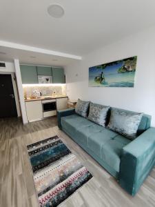 a living room with a blue couch and a kitchen at Euphoria Olimp in Olimp