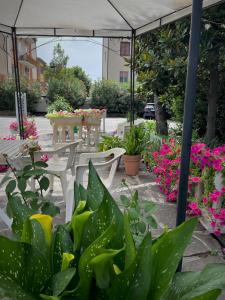 een patio met een tafel, stoelen en bloemen bij Hotel Astor in Modena