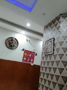 Hotel Diamond Ring Chandigarh في شانديغار: غرفة بها جدار مع لوحات على الحائط