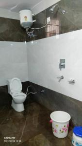 a bathroom with a toilet and a bucket at Hotel Diamond Ring Chandigarh in Chandīgarh