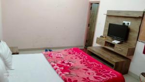 a bedroom with a bed with a red blanket at Hotel Diamond Ring Chandigarh in Chandīgarh