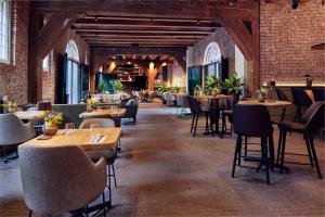 a restaurant with tables and chairs in a brick building at Hotel Arsenaal Delft in Delft
