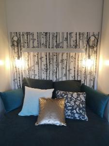 een bank met kussens en een zwart-witte muur bij Cozy Woodland Oasis - Superbe appartement rénové, calme et lumineux - BEC in Bons