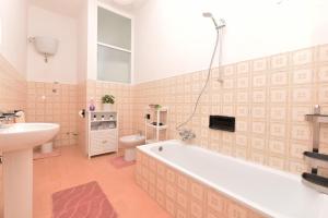 ein Badezimmer mit einer Badewanne, einem Waschbecken und einem WC in der Unterkunft La Terrazza sugli Dei in Pianillo