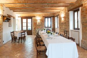 un comedor con una mesa larga con mantel blanco en Collerovere Country House, en SantʼAngelo in Pontano