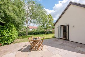 a patio with a table and chairs in a yard at Hattie's in Saxmundham