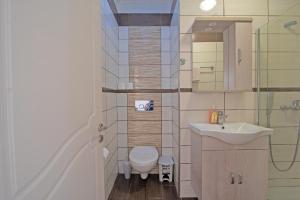 a bathroom with a toilet and a sink at Andromaches sea view studio in Achílleion +12 photos