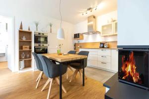 uma cozinha com uma mesa e cadeiras e uma lareira em Quartier 7 App 04 em Ahlbeck