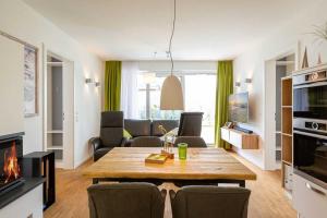 uma sala de estar com uma mesa e cadeiras e uma lareira em Quartier 7 App 04 em Ahlbeck