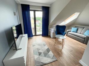 a living room with a couch and a chair at Villa Continental in Pobierowo