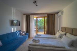 ein Hotelzimmer mit 2 Betten und einem blauen Sofa in der Unterkunft Casa D Argento in Veliko Gradište