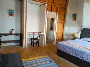 1 dormitorio con cama, mesa y escritorio en Mancora Beach House, en Máncora