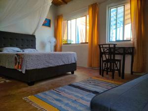 - une chambre avec un lit, une table et des chaises dans l'établissement Mancora Beach House, à Máncora