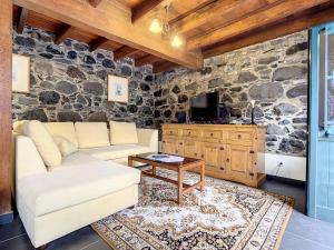 a living room with a stone wall at Villa Bella Vista by Atlantic Holiday in São Vicente