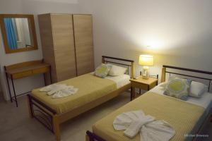 a hotel room with two beds and a mirror at Evilion Donoussa Studios in Donoussa