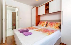 sypialnia z dużym białym łóżkiem z fioletowymi poduszkami w obiekcie Apartment Valsaline 2182 w Puli