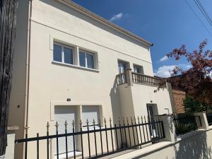Biały dom z czarnym płotem w obiekcie Villa Tenjin Chambre 10 w mieście Bondy