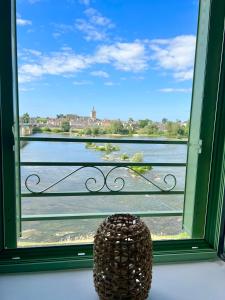 ein großes Fenster mit Blick auf das Wasser in der Unterkunft Gite LA VUE LOIRE Appartement in Saint-Denis-de lʼHôtel