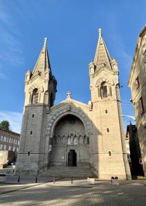 una gran iglesia de piedra con dos torres en una calle en Chez Mary, en Vanosc