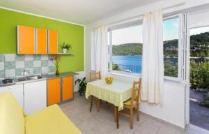 a kitchen with a table and a kitchen with a window at Guest House Busurelo in Polače