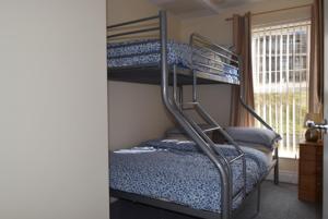 a bedroom with two bunk beds and a window at 46 west strand avenue in Portrush