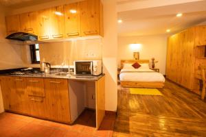 uma cozinha com um lavatório e uma cama num quarto em Patan Wittys hotel em Pātan