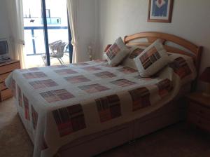 sypialnia z dużym łóżkiem z drewnianym zagłówkiem w obiekcie Stunning Apartment - Playamarina 2 Cabo Roig w mieście Orihuela Costa +11 zdjęć