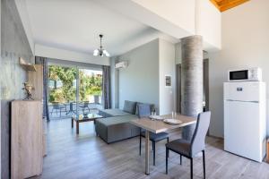 a kitchen and living room with a table and a couch at Aristos Garden Apartments in Kalithies