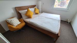 a bed with yellow pillows and a chair in a room at Holiday home Balatonlelle - Balaton 19095 in Balatonlelle +42 photos