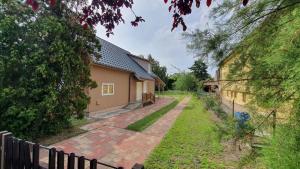 a house with a fence next to a yard at Holiday home Balatonlelle - Balaton 19095 in Balatonlelle