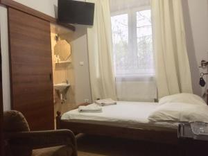 a small bedroom with a bed and a window at Pensjonat Przy Błoniach in Krakow