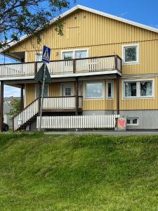 ein gelbes Haus mit einem blauen Schild davor in der Unterkunft Frost Longstay Sundellsgatan 3 C in Haparanda