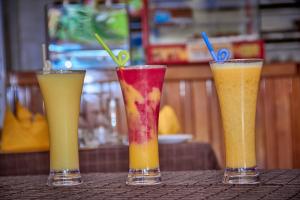 tres diferentes bebidas de colores sentadas en una mesa en Hoima Buffalo Hotel & Business Hub LTD, en Hoima