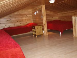 a room with two beds in a log cabin at Kuerkaltio Holiday Village in Äkäslompolo