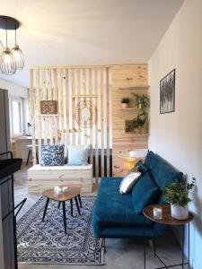 een woonkamer met een blauwe bank en een tafel bij Cozy Woodland Oasis - Superbe appartement rénové, calme et lumineux - BEC in Bons