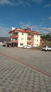 un grand bâtiment blanc sur le côté d'une route dans l'établissement MELEK APART PANSİYON, à Denizli