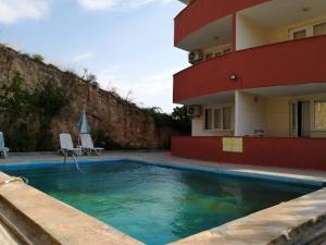 a swimming pool in front of a building at MELEK APART PANSİYON in Denizli